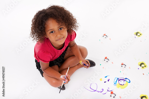 Photo: Little African Asian girl painting on the floor Little African Asian girl painting on the floor