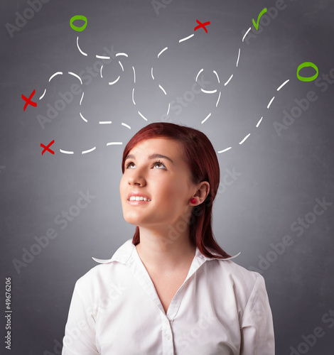 Photo: Young woman thinking with abstract marks overhead Young woman thinking with abstract marks overhead
