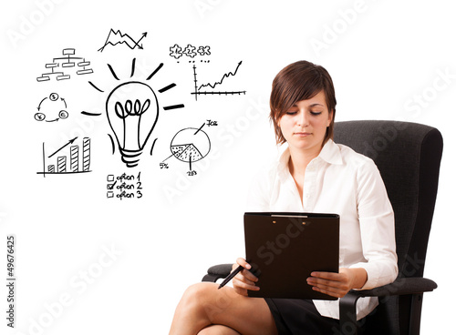 Photo: Young business woman presenting light bulb with various diagrams Young business woman presenting light bulb with various diagrams