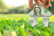 Foto: Hand holding banknote house icon,real estate concept. Hand holding banknote house icon,real estate concept.