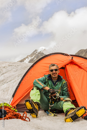 Photo: The climber in tent against Mountains Altai The climber in tent against Mountains Altai