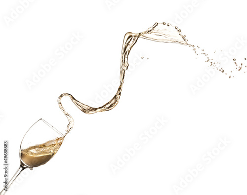 Photo: White wine splashing out of glass, isolated on white background White wine splashing out of glass, isolated on white background