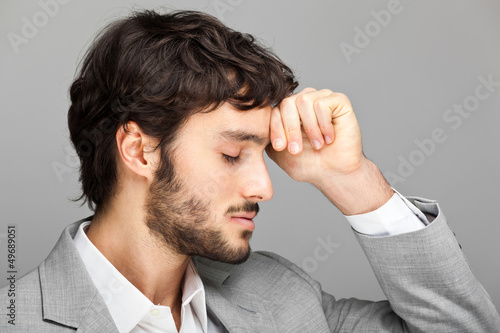 Photo: Portrait of a young business man looking depressed Portrait of a young business man looking depressed