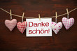 4 Stoffherzen mit Karte und Danke schön auf Holzbrett