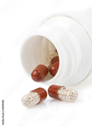 Photo: pills and bottle on white pills and bottle on white