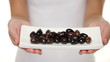 Olives - woman showing kalamata olive plate