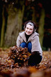 A woman gathering leaves in autumn time