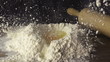 Child breaking an egg onto a heap of flour