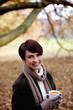 A woman holding a cup of soup in autumn time