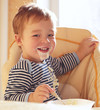 Foto: Two year old boy smiles and eating porridge. Two year old boy smiles and eating porridge.