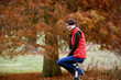 A woman sitting on a fence in autumn time