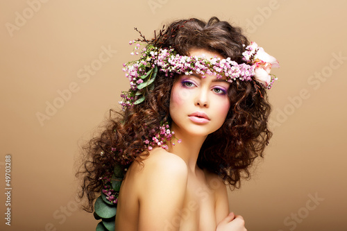 Photo: 8 March. Springtime. Woman with Wreath of Flowers over beige 8 March. Springtime. Woman with Wreath of Flowers over beige