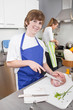 Junge hilft der Mutter beim Kochen in der Küche