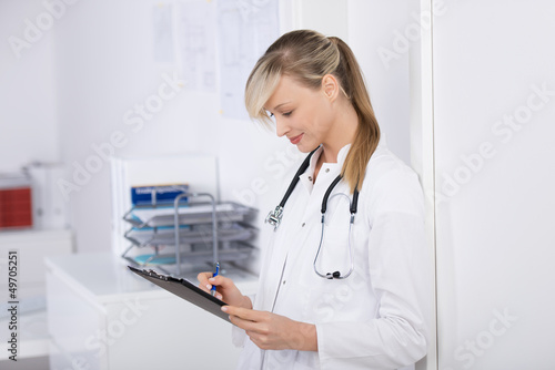 Photo: ärztin schaut auf formular ärztin schaut auf formular