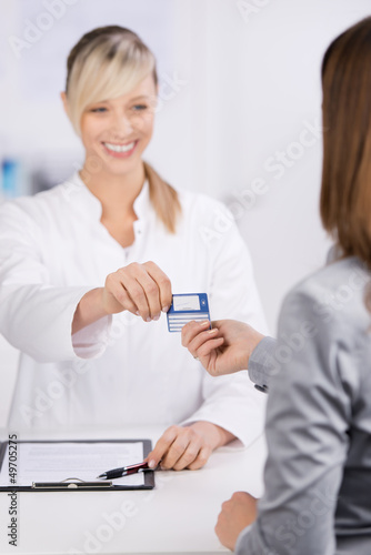 Photo: patientin überreicht versicherungskarte patientin überreicht versicherungskarte