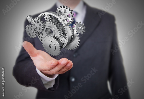 Photo: Businessman showing gears Businessman showing gears