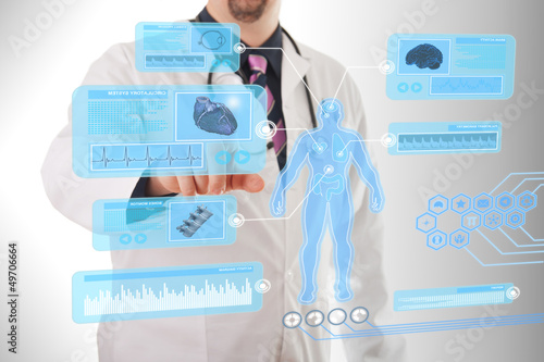 Photo: Male doctor working on a futuristic touchscreen display Male doctor working on a futuristic touchscreen display