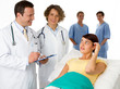 A patient being visited by a doctor and nurse