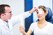 Optometry concept - pretty young woman having her eyes examined