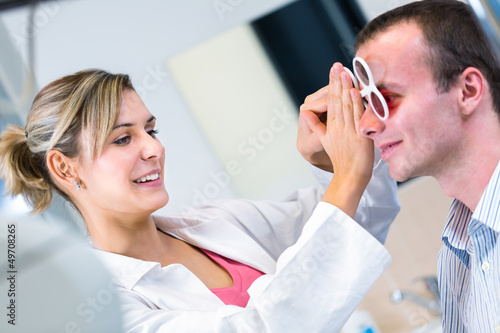 Photo: Optometry concept - handsome young man having his eyes examined Optometry concept - handsome young man having his eyes examined