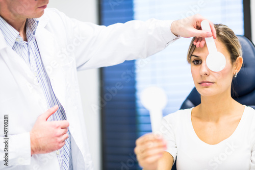 Photo: Optometry concept - pretty young woman having her eyes examined Optometry concept - pretty young woman having her eyes examined