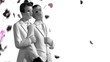 Confetti falling on gay groom cake toppers in black and white
