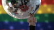 Gay groom cake toppers in front of rainbow flag