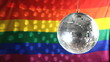 Disco ball revolving against gay pride flag