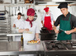 Chefs Working In Restaurant Kitchen