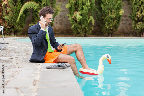Photo: Funny Young Businessman with SwimmingTrunks next to the Pool Funny Young Businessman with SwimmingTrunks next to the Pool