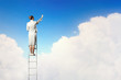 Businesswoman standing on ladder