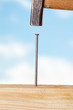 Hammer and nail with wooden board