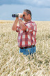 Man with binoculars in cornfield