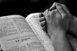 Hands Praying on Bible