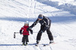 Kind mit Erwachsenen beim Skifahren lernen