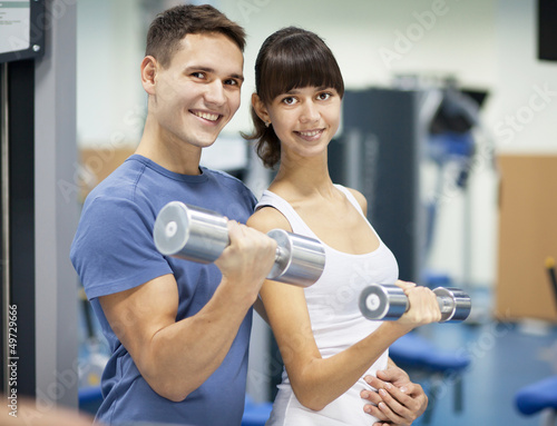 Photo: Cheerful young couple in a gym Cheerful young couple in a gym