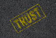 Trust word stamped on asphalt background