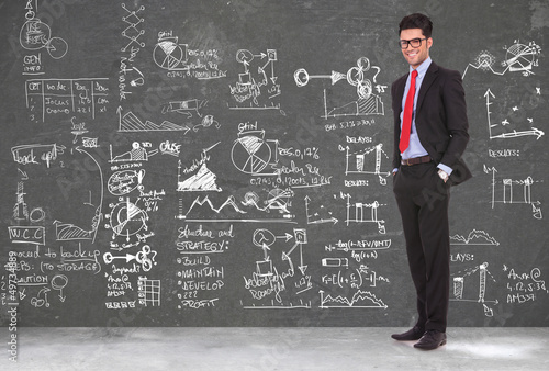 Photo: business man stands in front of blackboard business man stands in front of blackboard