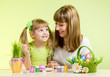 mother with child girl play and paint easter eggs