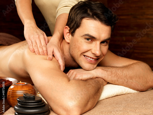 Photo: Smiling man having massage in the spa salon Smiling man having massage in the spa salon