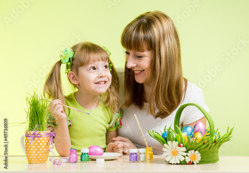 Photo: mother with child girl play and paint easter eggs mother with child girl play and paint easter eggs