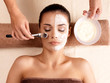 Spa therapy for woman receiving facial mask