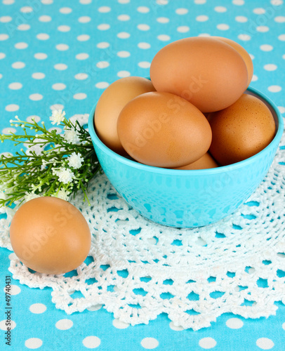 Photo: Eggs in bowl on blue tablecloth close-up Eggs in bowl on blue tablecloth close-up