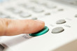 Office life, hand pressing start button on fax, copy machine