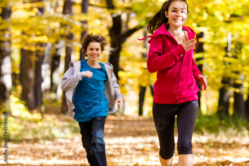 Photo: Girl and boy running, jumping in park Girl and boy running, jumping in park