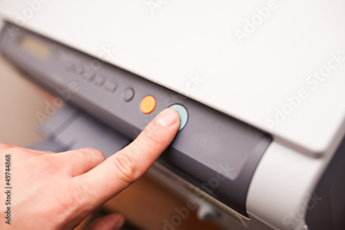 Photo: Office life, hand pressing start button on fax, copy machine Office life, hand pressing start button on fax, copy machine