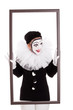 weiblicher Clown im Rahmen blickt wütend