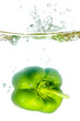 grüne Paprika fällt ins Wasser vor weiß