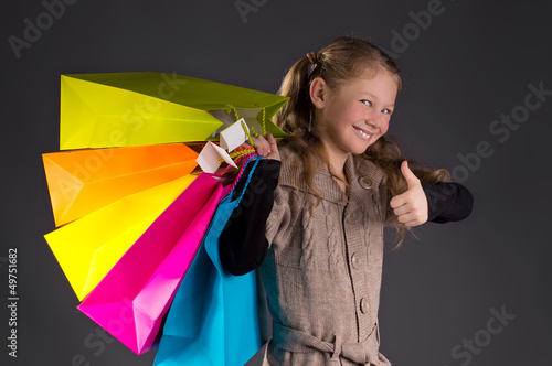 Photo: Fröhliches Mädchen mit Zöpfen und bunten Taschen Fröhliches Mädchen mit Zöpfen und bunten Taschen