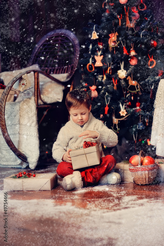 Photo: boy with a basket of toys in the background of a beautiful Chri boy with a basket of toys in the background of a beautiful Chri